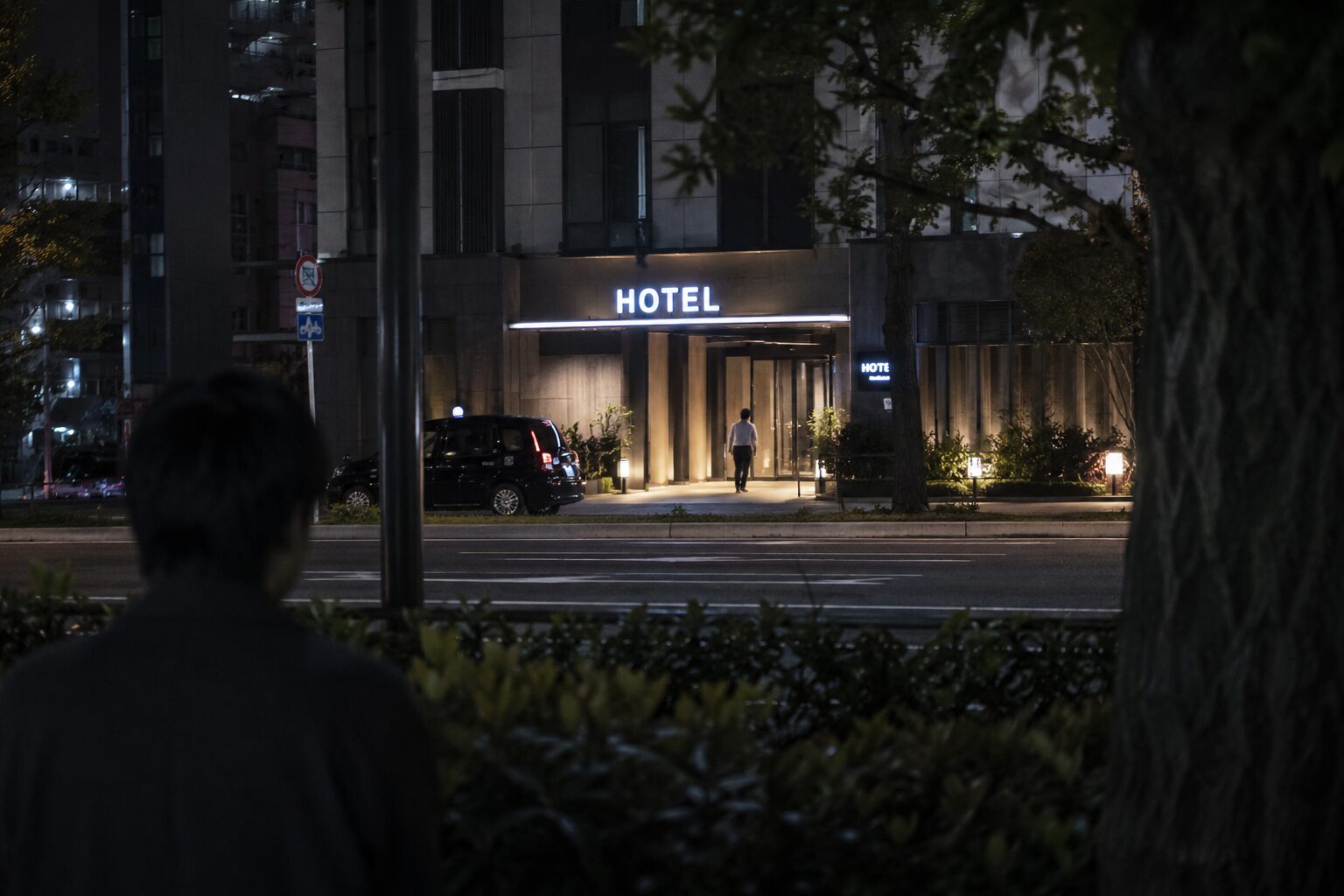 ホテルの入口を離れた場所から見張るイメージ